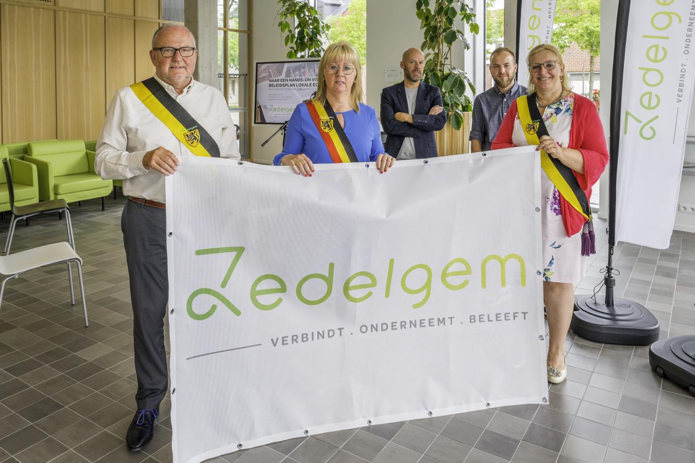 Burgemeester en schepenen met de campagnevlag van dit project.